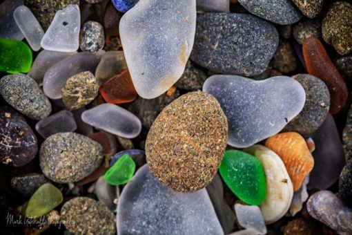 Multiple colored glass fragments mixed with rock on Glass Beach in Mendocino County