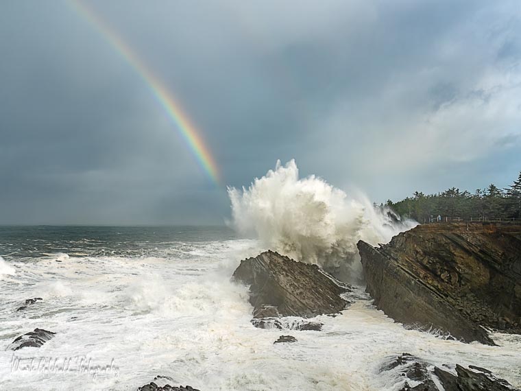 Photo of crashing waves and a rainbow at Shore Acres State Park