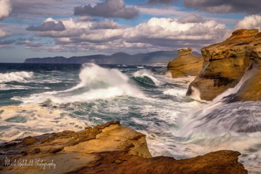 Waves roll in at Cape Kiwanda, smashing into the sandstone cliffs