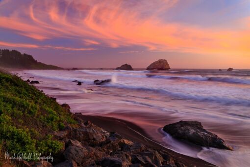 The sunsets awesome colors reflected on the sand and in the waves
