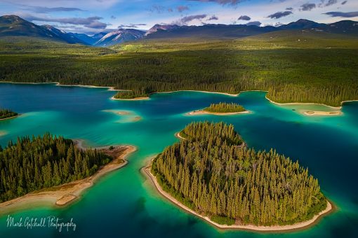 Aerial view of turquoise lake, islands, and mountains